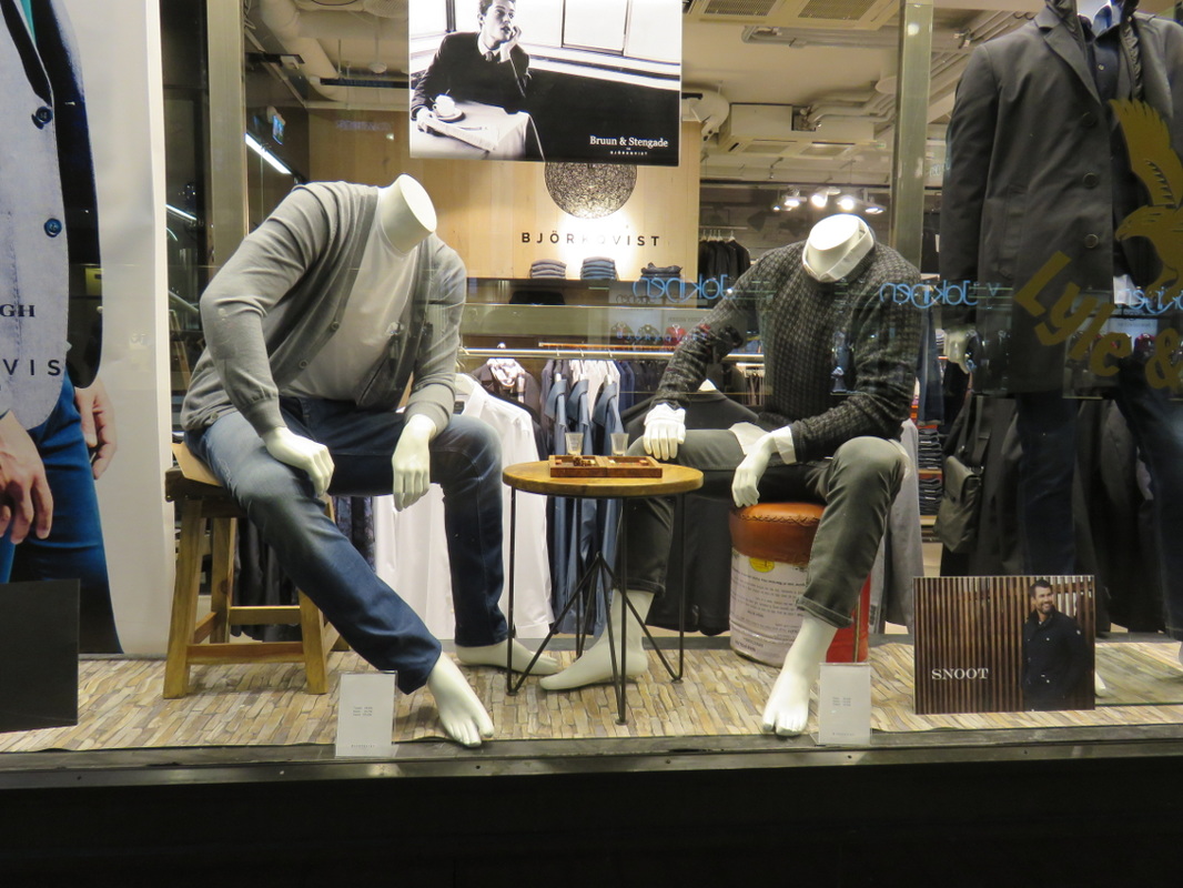 headless mannequins playing board game games clothing store clothes shop window advertisement city street photography